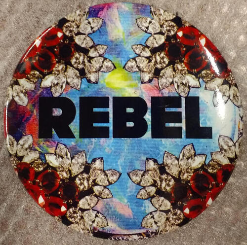 Button van metaal met opschrift REBEL