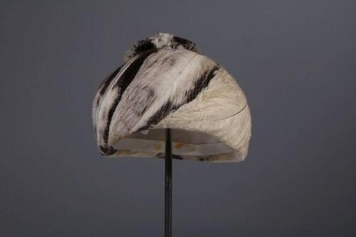 Toque bedekt met beige en bruine veren en afgewerkt met pompom