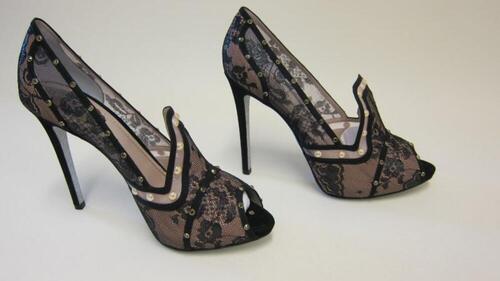 Hoge zwarte pumps met kant, stras en parelversiering en een zilverkleurige zool