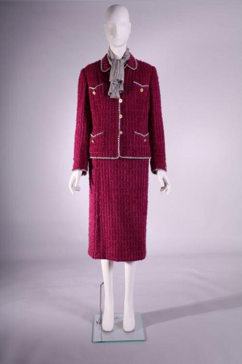 Ensemble bestaande uit jasje en rok in fuchsia bouclé met zilverkleurige boord, blouse in…