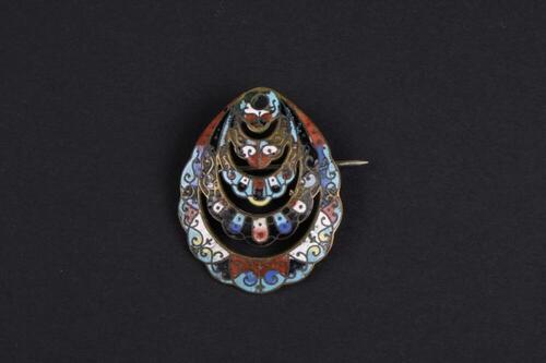 Schelpvormige broche in koper en gekleurd glazuurwerk