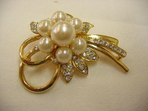 Goudkleurige, metalen broche met imitatieparels en glazen steentjes