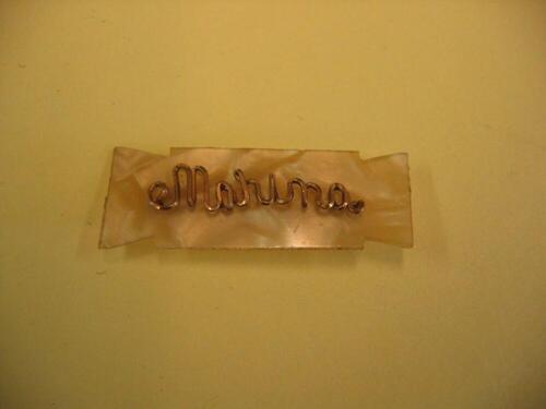 Broche in paarlemoerkleur met gouden letters
