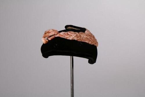 Hoed in zwart fluwelen mengweefsel met zalmkleurige versiering