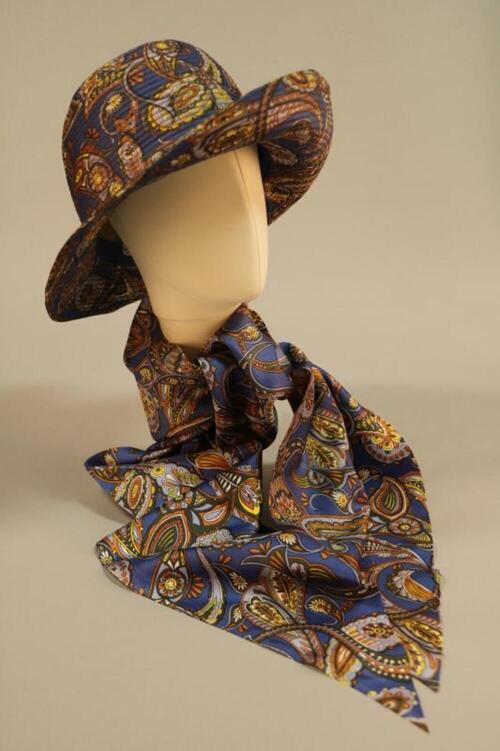 Hoed in blauwe zijde met felgekleurde paisley