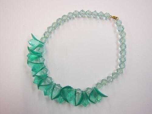 Groene doorschijnende plastic halsketting in bloemvorm.