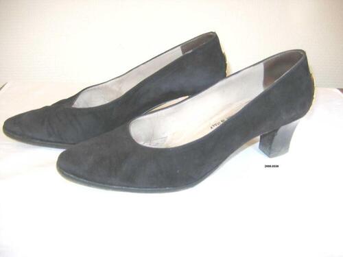 Zwarte suède pumps met een goudkleurig blaadje op de hiel