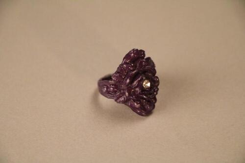 Ring in donkerblauw plastic in vorm van bloem versierd met stras