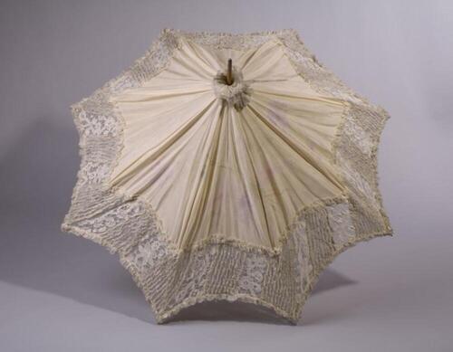 Parasol in beige zijde versierd met bloemen en een boord van ruches en kant