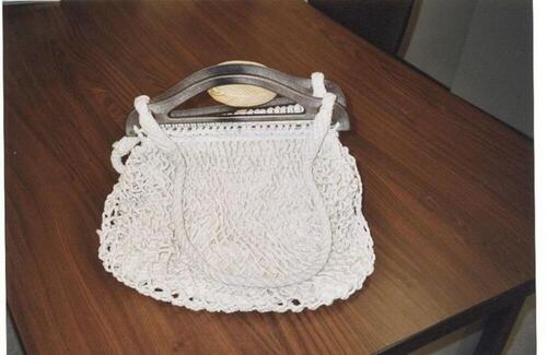 Handtas in witte macramé en plastic handvaten