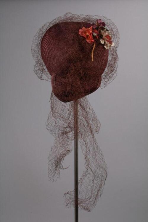 Hoed in bordeauxkleurig stro met bloemen versierd