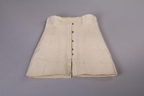 Korset uit witte batist, afgewerkt met brede strook kant.