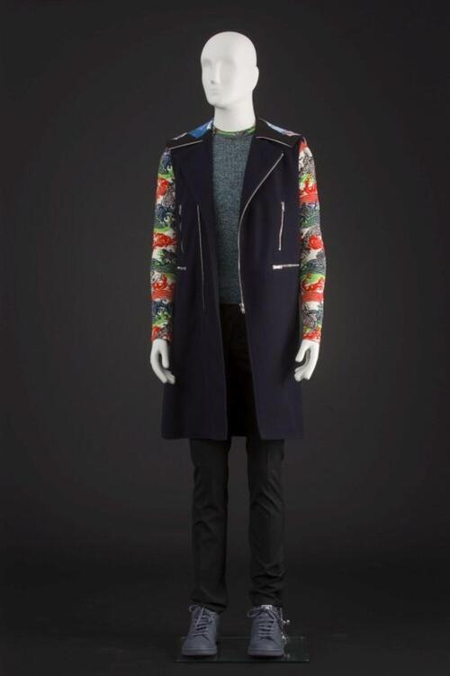 Ensemble bestaande uit gilet, trui, zwarte broek, grijze sneakers, T-shirt met koi-print en sokken
