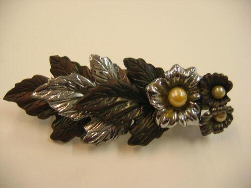 Grote, zilver- en bronskleurige haarspeld met blad- en bloemmotief