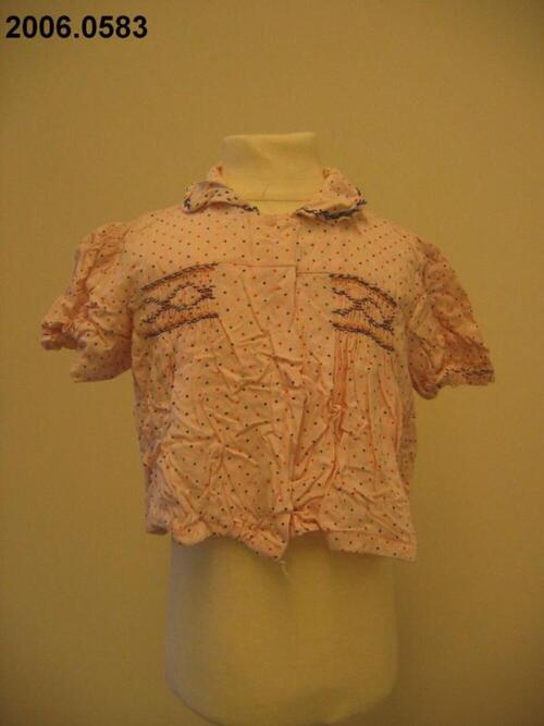 Blouse in roze katoen met rode stippen en smokversiering