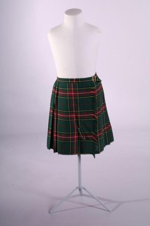 Groen, rood, geel en wit geruit jong meisjesrok (kiltmodel) met koperen gesp en grote speld