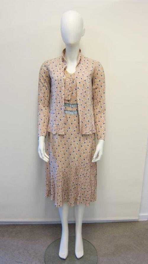 Ensemble in bestaande uit een jurk en een blouse in zalmroze bedrukking van ecrukleurige bloemen en…