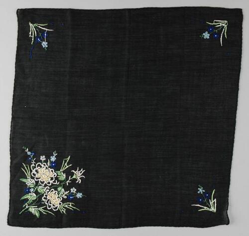 Vierkante zwart katoenen zakdoek met borduursel in groen, blauw en wit, op drie hoeken kleine bloem…