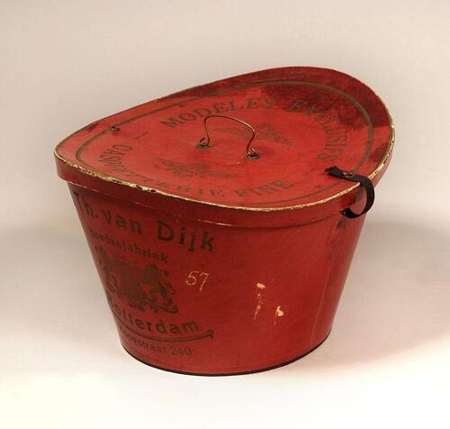 Bordeauxrode kartonnen hoedendoos "MODELLES EXCLUSIFS, CASQUETTERIE FINE" en "G. Th. Van Dijk,…