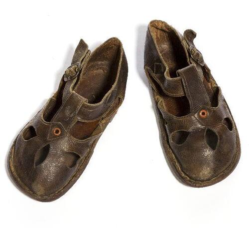 Een paar sandalen (kind) van bruin leer met ronde neus, versierd met vijf open gaten in vorm…