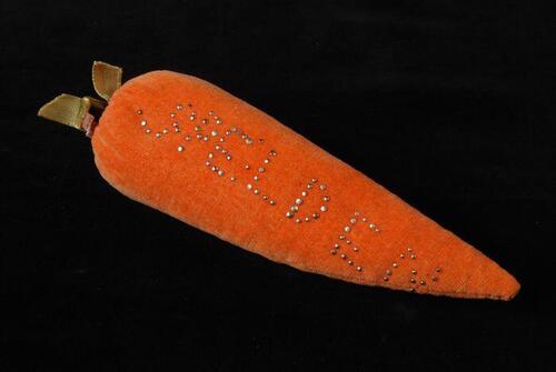 Speldenkussen in de vorm van een peen van oranje en groen fluweel, "spelden"