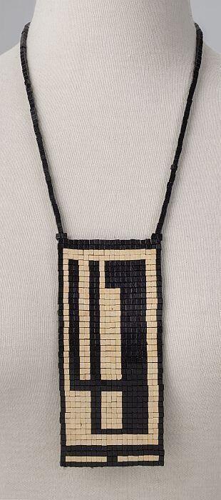 ketting van platte kubusvormige zwarte en ecrukleurige kralen met asymmetrisch motief