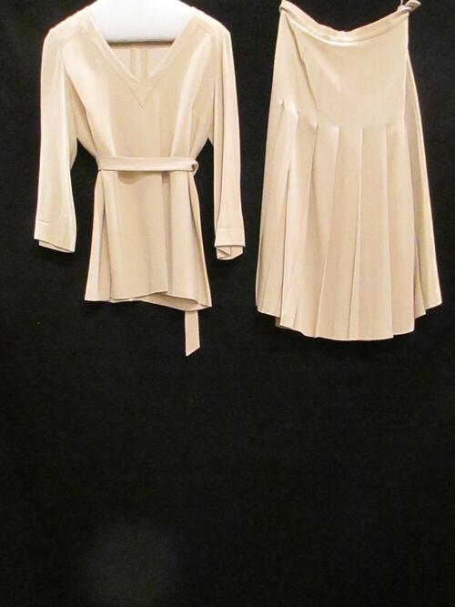 Ensemble bestaande uit plooirok, blouse en ceintuur van zandkleurige crèpe