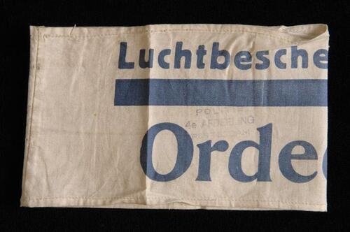 Mouwband, wit katoen met opdruk in donkerblauw, "Luchtbeschermingsdienst Ordedienst", twee stempels