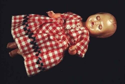 Kleine pop, Witte baby van roze kunststof met slaapogen en draaibare ledematen in wit katoenen…