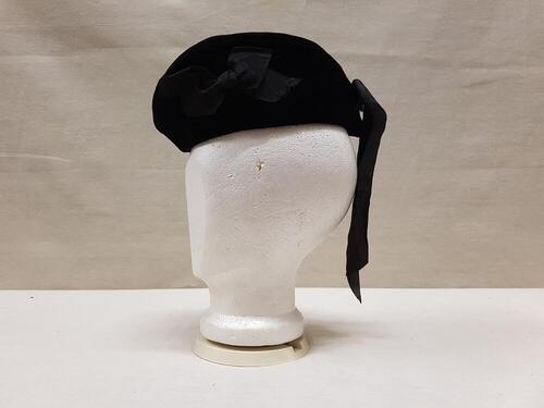 Baret of hoedje van zwart fluweel met zwart zijden lint van strik van idem