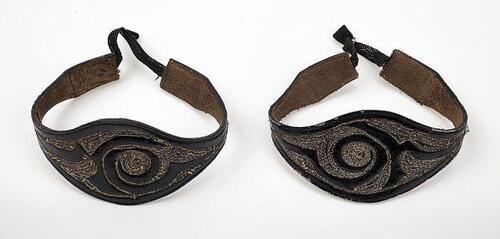 Paar zwarte lakleren armbanden met borduursel in zilverraad