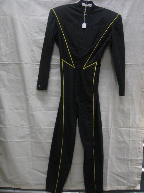 Jumpsuit van zwarte katoen met gele bies, model met lange mouwen, lange smalle pijpen en…