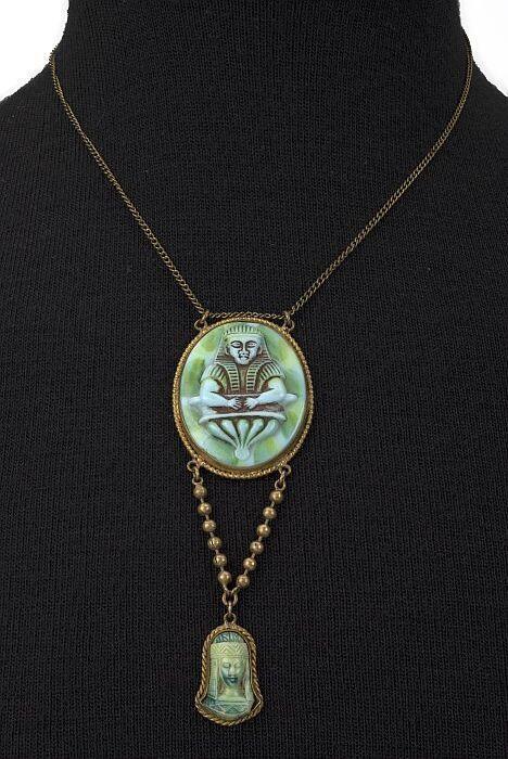 Koperen ketting met ovaal medaillon waarin reliëf van Egyptisch kopje van groenblauw plastic, onder…