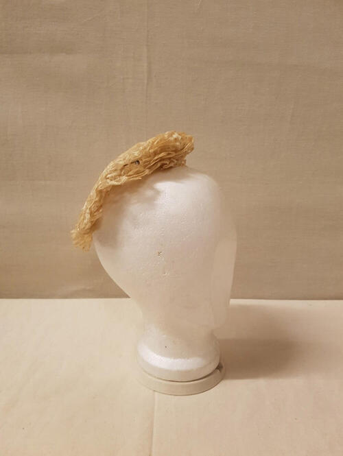 Coiffure / Kap, geheel bestaande uit stroken crèmekleurig geschulpt machinekant. 4 sierspelden met…