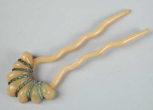haarspeld, U-vormige pen van beige kunststof met waaiervormig ornament met schakelkettingje