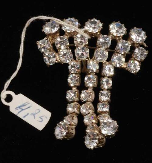 Eén broche, met veel kleine kunstdiamantjes in een zilverkleurige vattin, kapper Van Vliet