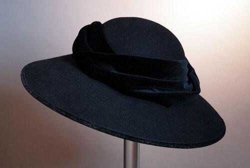 Zwarte vilten cloche, velours chiffon gedrapeerd om de bol en afgebiesde randen