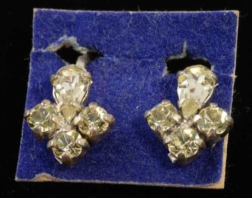 Eén paar oorbellen, clip met gele kunstdiamantjes in zilverkleurige metalen vattin, op blauw…