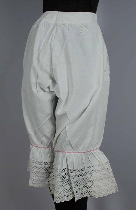 Onderbroek met lange pijpen van wit linnen boven de pijpen sierband met rood meandermotief,…