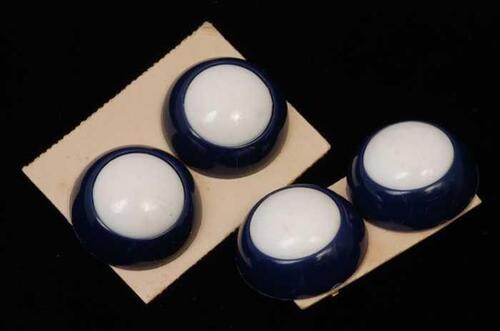 Twee paar oorbellen, clip met ronde knop met brede donkerblauwe rand en witte kern, op aparte…