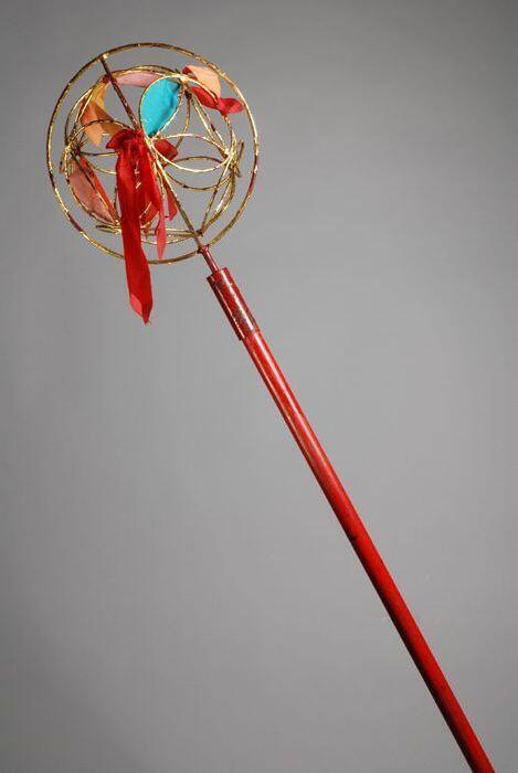 Dresseerbol of 'dancing ball', lange rode stok met een open goudkleurige metalen bol met…
