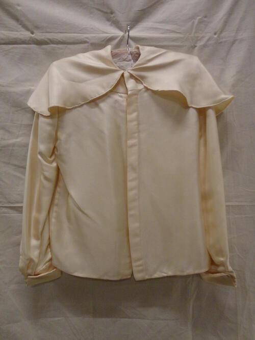 Blouse van crèmekleurig zijde in keperbinding met platte kraag in pelerine vorm