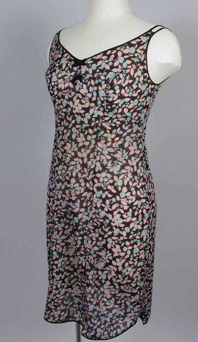 Korte zwarte onderjurk, met roze en turquoise bloemen, zwart afgebiesd, tussen cups en boven de…