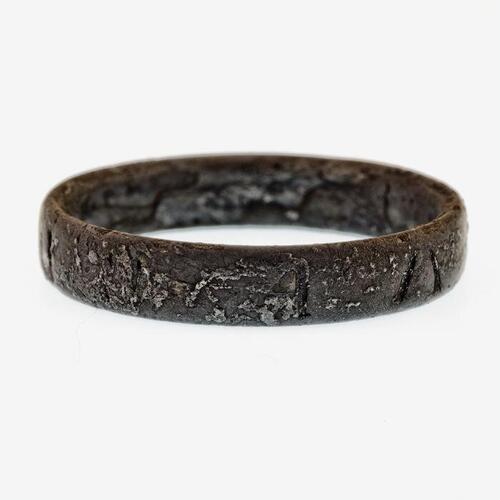 zilveren ring waarop enkele letters en figuren