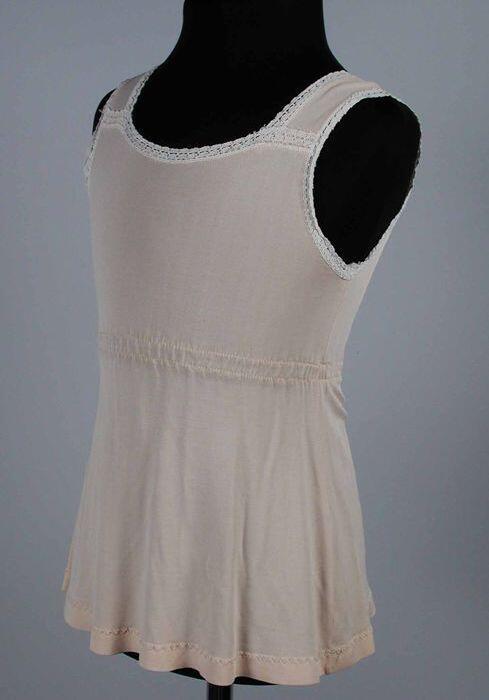 Kinderonderjurk van roze tricot kunststof hemdmodel met elastiek in de taille en kantgarnering, …