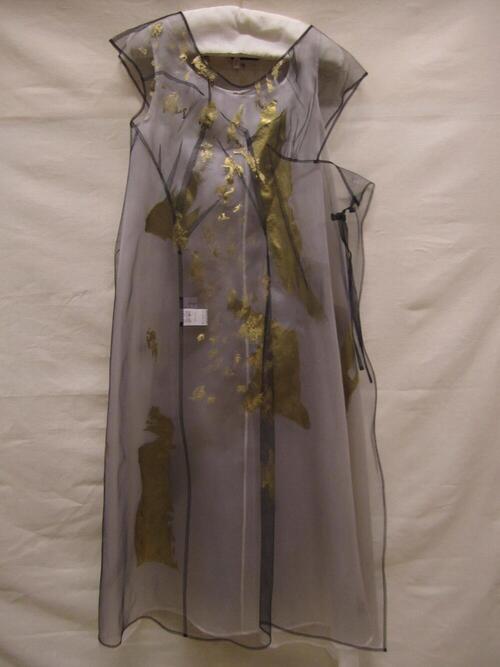 Ensemble, tweedelig, bestaande uit een onderjurk van witte zijden organza, met goud beschilderd en…