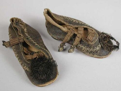 Paar miniatuur schoenen van zwart leer, wit sierstiksel rondom, lage hak en drie wreefbanden,…