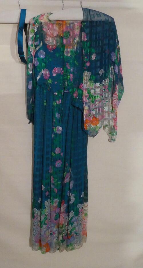 1) Avondjurk van transparante zijde met blauw fond en veelkleurige bloemmotieven. 2) Ceintuur…