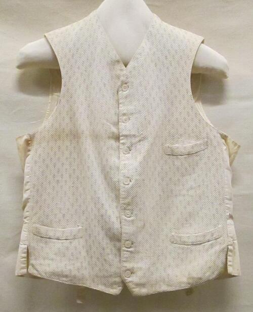 Vest (man) van wit wafeldoek met ingeweven blauw motiefje, achterpand en voering van wit katoen