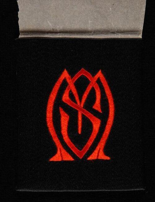 Geborduurd monogram "MS" in platsteek met rode zijde op zwart satijnen ondergrond, proefstuk